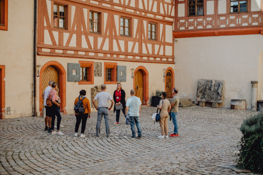 Gruppe macht Stadtführung in Forchheim im Innenhof der Kaiserpfalz